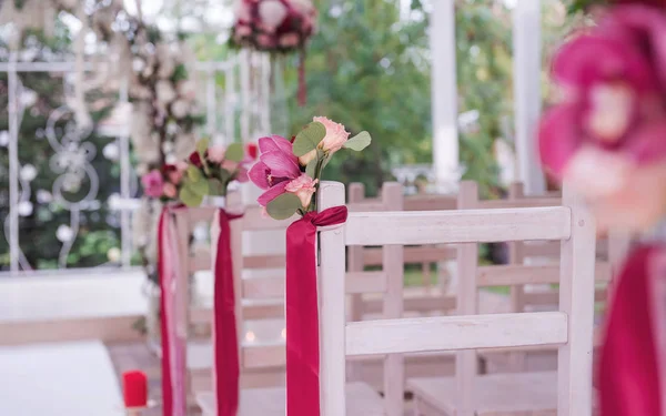 Boutonniere from fresh flowers on a back of a white chair