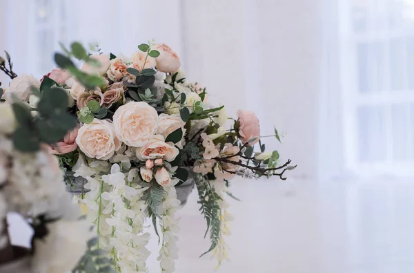 Flores artificiales con estilo en un jarrón de vidrio de pie en el suelo . — Foto de Stock