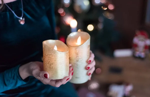 Vuur in de handen van de vrouw. Twee brandende kaarsen in de handen van de vrouw. Kerst dromen. — Stockfoto
