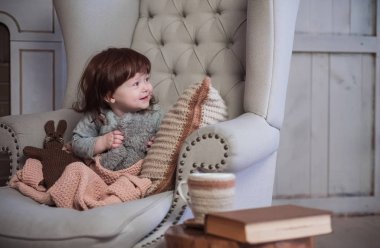 Çocuk büyük bir sandalyede oturuyor. İskandinav tarzı.