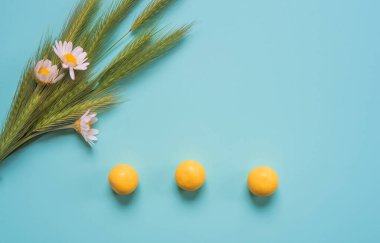 Güzel mavi arka planda papatya ve yabani otlarla dolu mini bir buket. Parlak sarı şeker ve taze çiçekler. Stil yaz arkaplanı