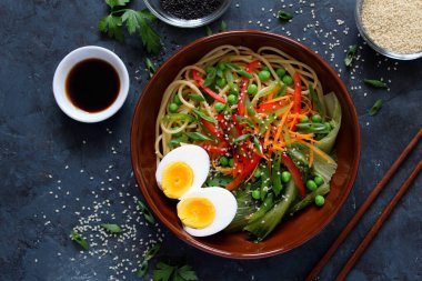 Sebzeli erişte ve arka planda yumurta. Kopyalama alanı olan üst görünüm. Asya yemekleri.