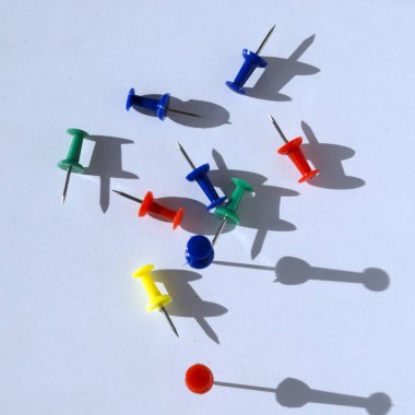 Beyaz arka plan üzerinde renkli pushpins düzensizce dağınık