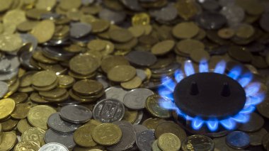 Doğalgaz yakıcı bir gaz mavi alevler paraları bir arka plan üzerinde Ocak. Enerji krizi kavramı. Doğal gaz için yüksek fiyatlar