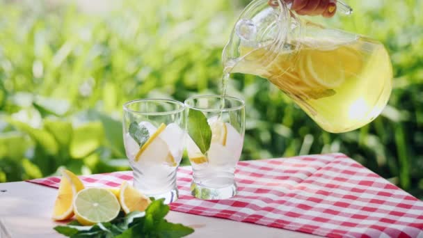Lemonade with ice, orange and lime slices in a glass — Stock Video