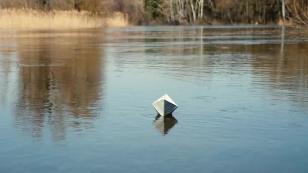 Un barco de papel flota en el agua — Vídeo de stock