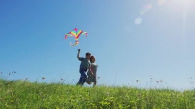 Çocuk erkek ve kız uçurtma uçan ile yürüyüş tadını çıkarın