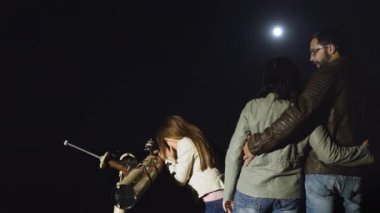 Mutlu aile bir teleskop ayda gece izlerken