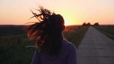 Yol boyunca çalışan bir kız silüeti