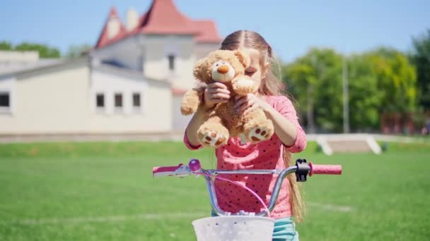 Retrato de una linda niña sentada en una bicicleta — Vídeos de Stock