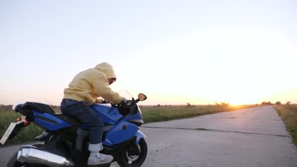 Niño pequeño está montando un juguete de motocicleta eléctrica — Vídeos de Stock