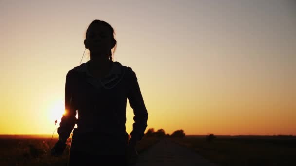 Silhouette eines Mädchens, das auf der Straße läuft — Stockvideo