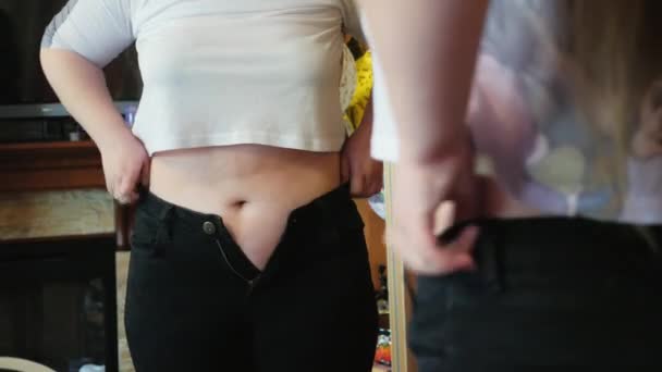 Gorda chica tener problemas con llegar en su favorito pantalones — Vídeo de stock