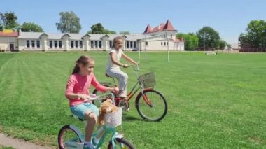 İki arkadaş döngüsü üzerinde yeşil çim sahada birlikte binmek