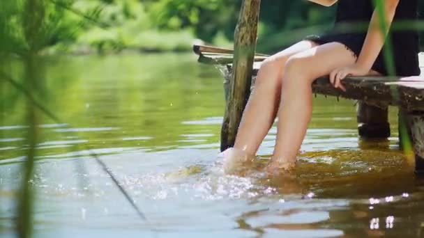 Holky nohy jsou šplouchání v rybníku — Stock video