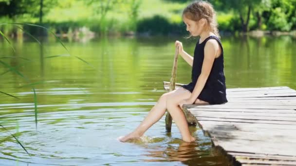 Ноги девочек плещутся в пруду — стоковое видео
