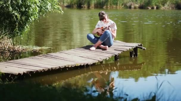 Menina bonita tocando ukulele guitarra — Vídeo de Stock