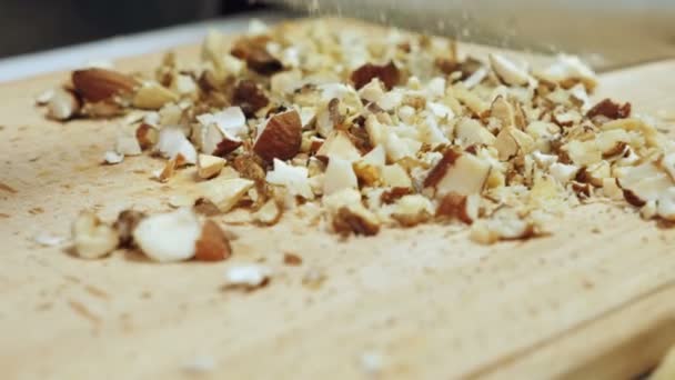 Chef-koks handen gemengde noten hakken op houten snijplank — Stockvideo