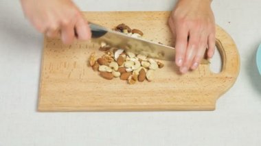 Karışık kuruyemiş doğrama ahşap kesme tahtası üzerinde kadın şefler eller