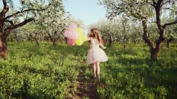 Šťastná dívka s bublinami v rozkvetlé zahradě — Stock video