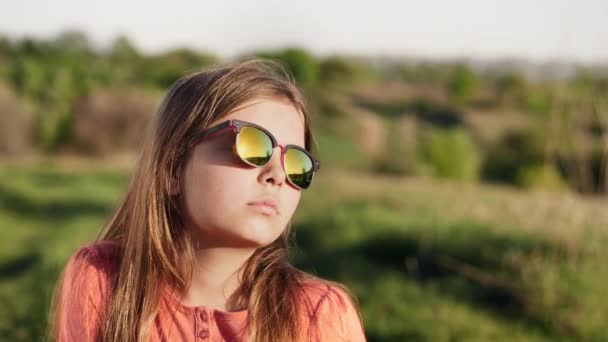 Porträt eines Mädchens mit Sonnenbrille bei Sonnenuntergang — Stockvideo