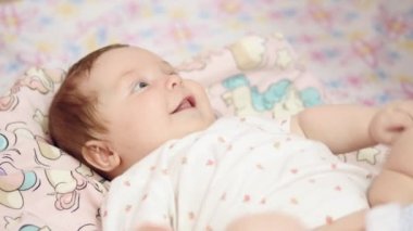 Sırt ve gülümseyen şirin bebek yatıyor