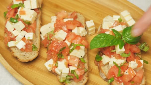Bruschetta con tomates, albahaca y queso — Vídeo de stock