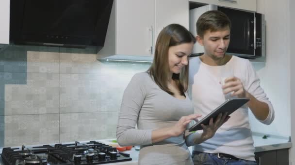 Couple heureux à la maison dans la cuisine en utilisant la tablette ensemble — Video