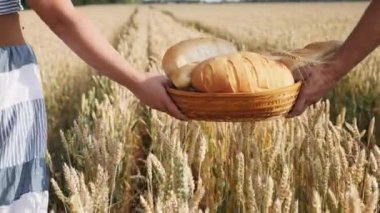 Kadın ve erkek elinde ekmek sepeti olgun buğday alanı taşımak.