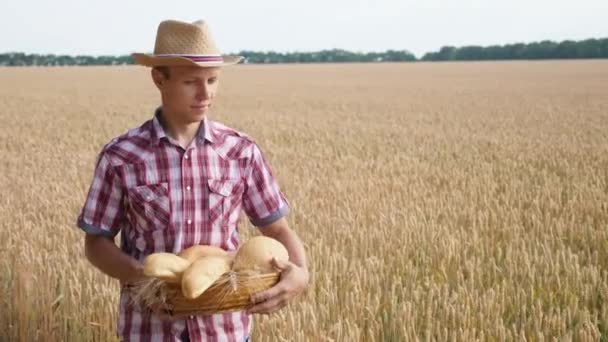 Boer loopt het tarweveld en draagt een mandje brood — Stockvideo