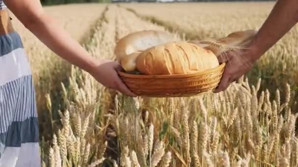 Kadın ve erkek elinde ekmek sepeti olgun buğday alanı taşımak. — Stok video