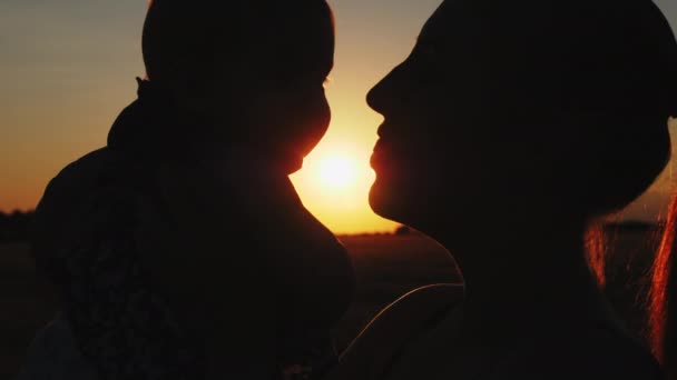 Silhuett av mor med barn vid solnedgången — Stockvideo