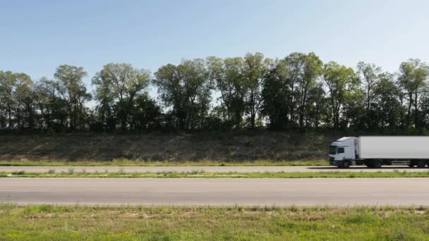 Um caminhão branco está se movendo ao longo da estrada — Vídeo de Stock