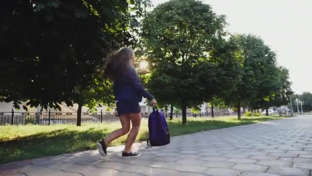 Дівчина махає рюкзак біжить по провулку — стокове відео