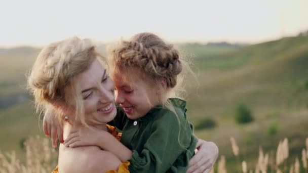 Mãe com sua filha em seus braços ao ar livre — Vídeo de Stock