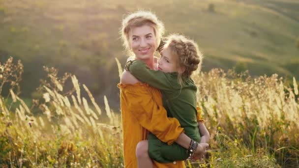 Mãe com sua filha em seus braços ao ar livre — Vídeo de Stock