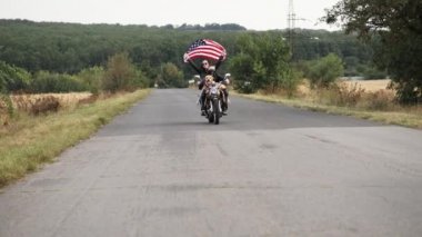 Bir köpek motorcularla ailesinin bir bayrak ile bir motosiklet binmek
