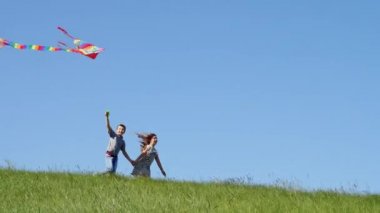 Uçan uçurtma ile yeşil tepeden aşağı çalıştırmak çocuk