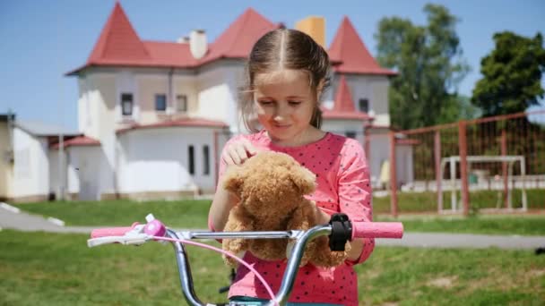 Una niña está sonriendo y abraza tu juguete de peluche favorito — Vídeos de Stock