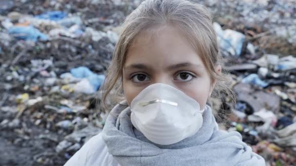 Porträt eines jungen Mädchens mit Atemschutzmaske auf der Müllkippe — Stockvideo