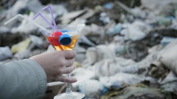 Ett glas med en giftig vätska, plast lock i handen av en kvinna — Stockvideo