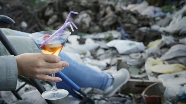 Un bicchiere con un liquido tossico, tappi di plastica nella mano di una donna — Video Stock