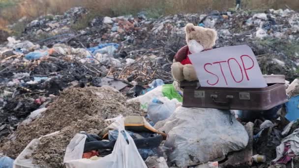 Oyuncak maskeli bir çöplüğü eski bir bavula oturur — Stok video