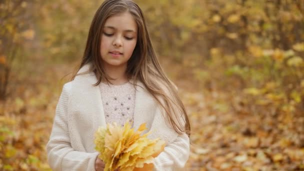 Милая девушка держит букет осенних листьев — стоковое видео