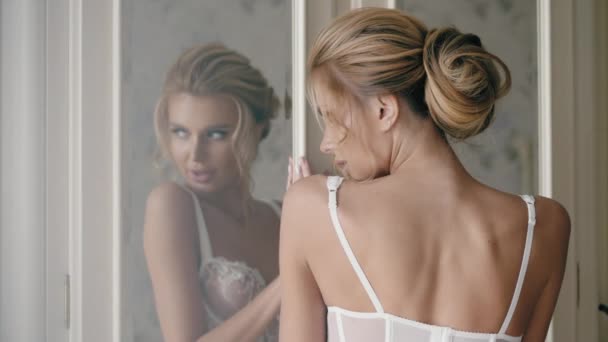 Молодая сексуальная девушка стоит в нижнем белье возле шкафа — стоковое видео