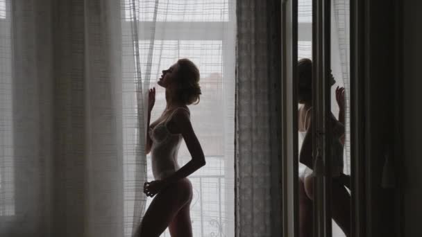 Силуэт сексуальная красивая девушка в нижнем белье в окне — стоковое видео