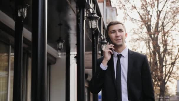 Jovem homem de negócios está falando no telefone inteligente — Vídeo de Stock