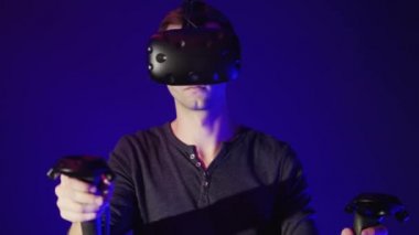 Genç adam modern sanal gerçeklik kulaklık gamepad ile kullanma
