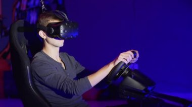 Genç adam araba sürücü simülatörü oynamak. Sanal gerçeklik