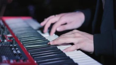 Klavye synthesizer piyano tuşlarında oynarken müzisyen. Müzisyen konser Sahne Alanı'nda bir müzik aleti çalıyor
